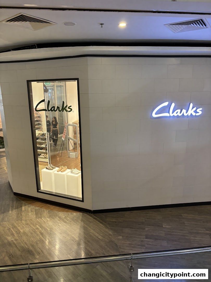 Exterior view of a Clarks Outlet store with a neon sign and window display.