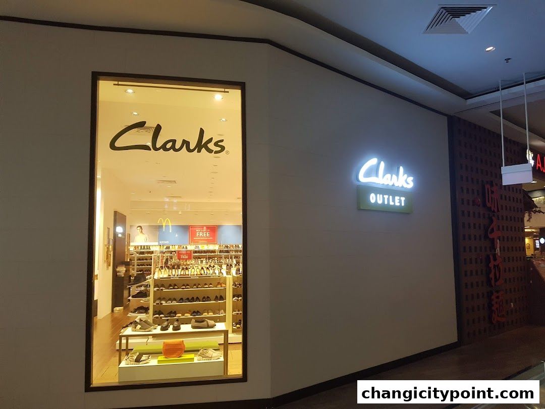 The exterior of a Clarks Outlet store, showcasing shoes displayed inside.