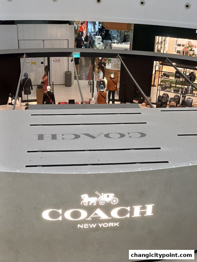 Coach Outlet store entrance with mannequins displaying apparel and bags.