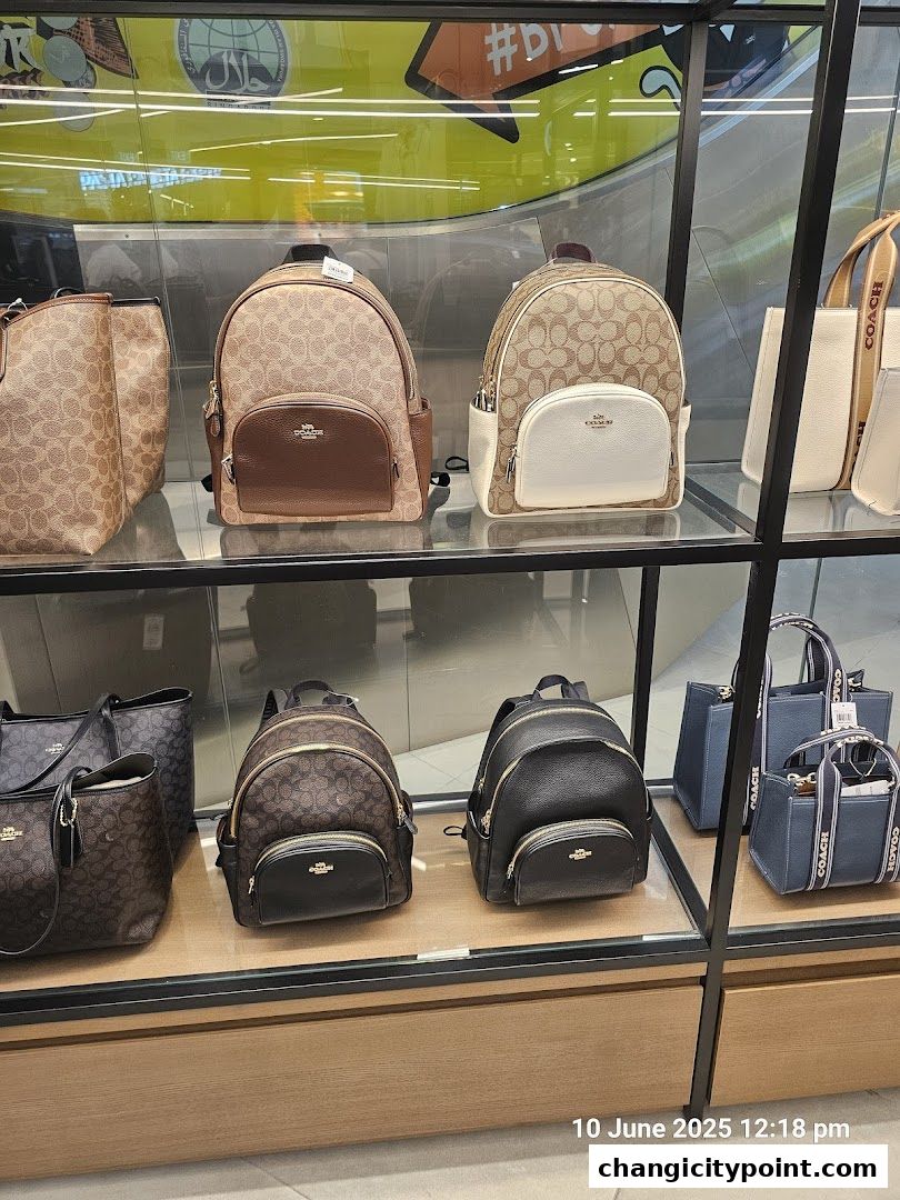 Coach Outlet display of various backpacks and handbags on shelves.
