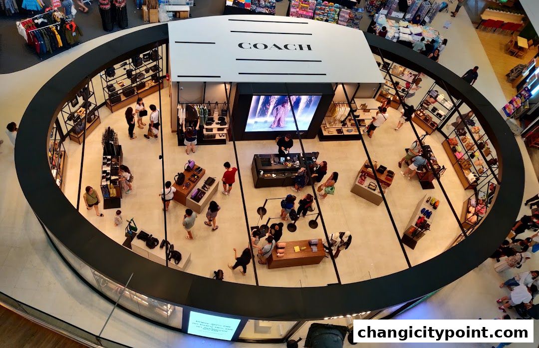 Aerial view of a Coach Outlet store showcasing handbags, wallets, and accessories with customers browsing.