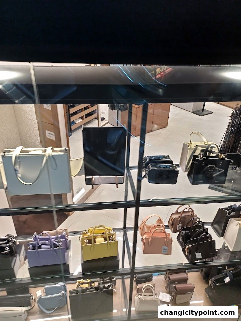 A display of various handbags in different colors and styles inside a retail store.