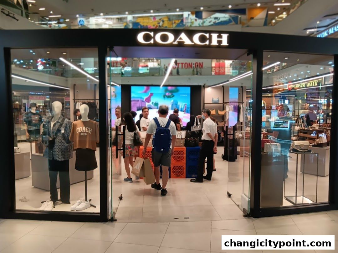 Coach Outlet store entrance with mannequins displaying apparel and handbags.