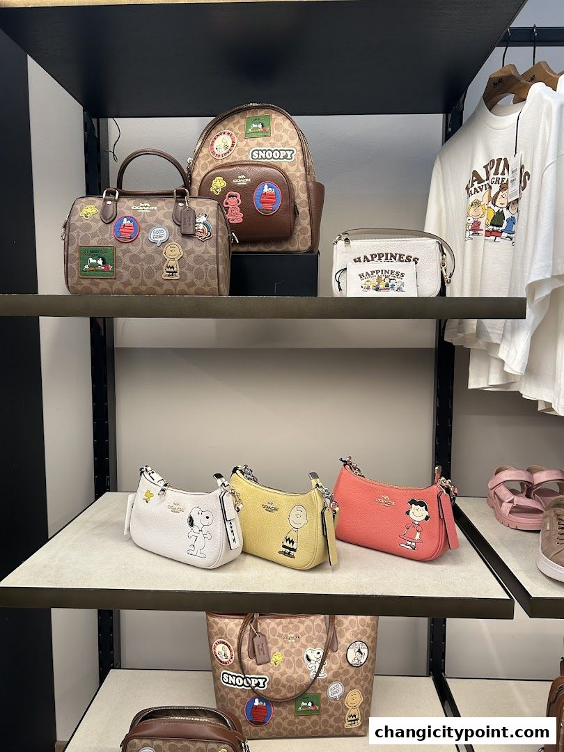 Coach Outlet display featuring Snoopy and Peanuts themed handbags and apparel.