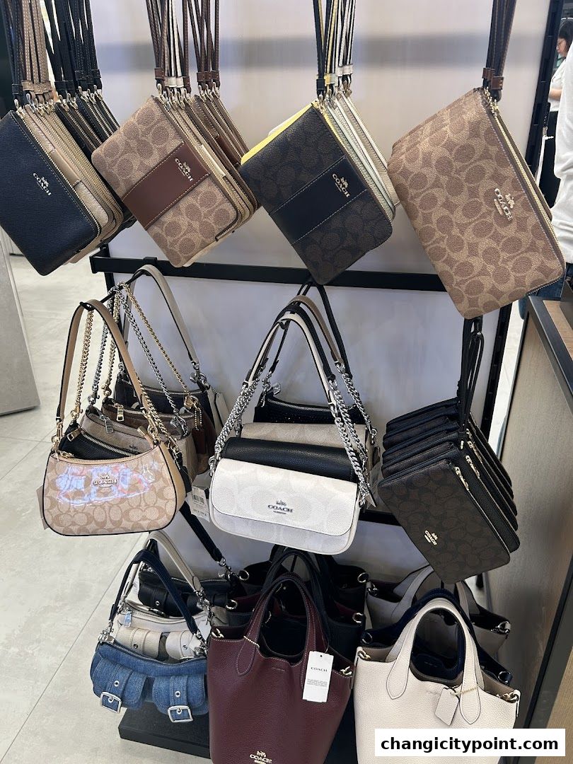 A display of various Coach handbags and wristlets in different styles and colors.