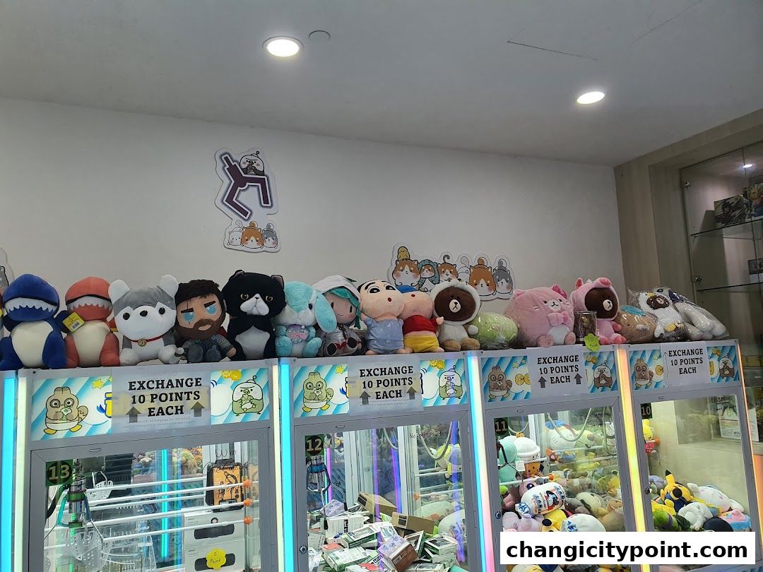 A row of plush toys displayed above several claw machines filled with prizes.