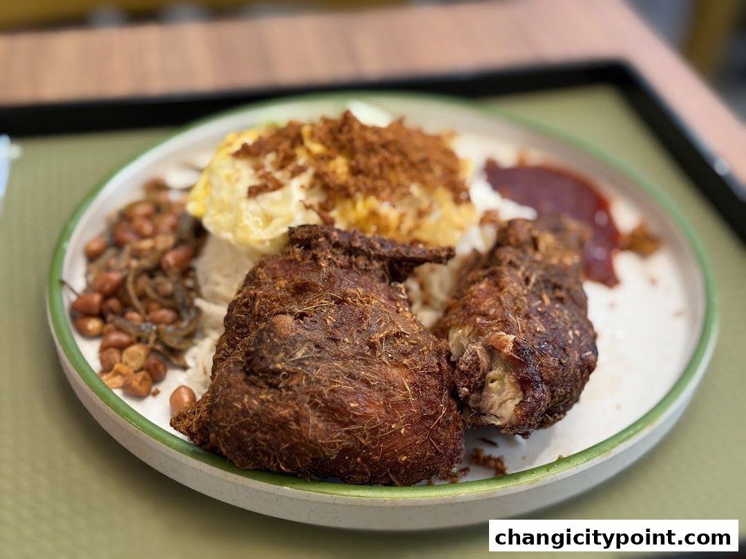 A close-up of a delicious Nasi Lemak dish with fried chicken and accompaniments.
