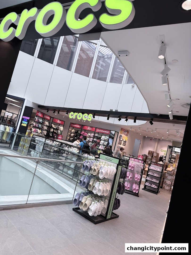 The Crocs Outlet store entrance with a display of colorful Crocs shoes and sale signs.