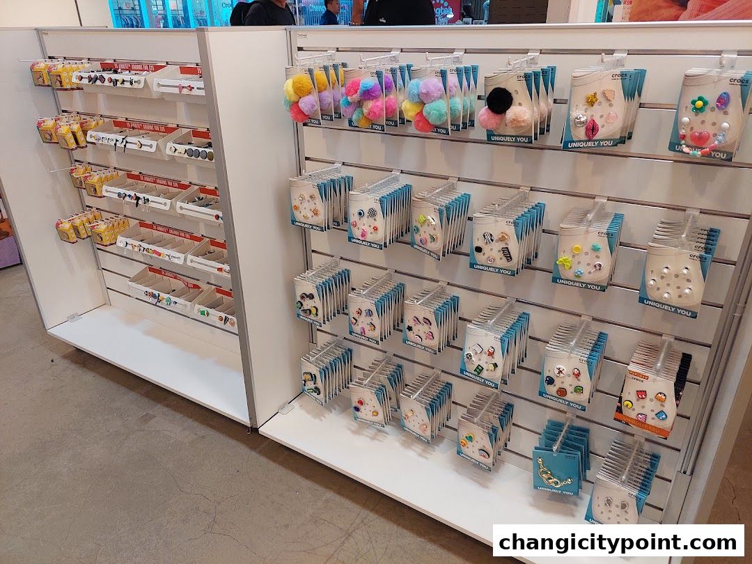 Display shelves filled with Crocs charms and accessories, including fluffy pom-poms and decorative Jibbitz.