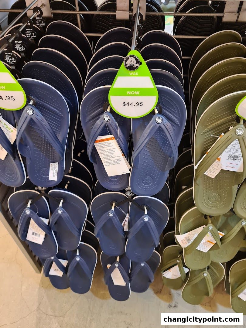 A display of navy blue and olive green Crocs flip-flops on hangers.