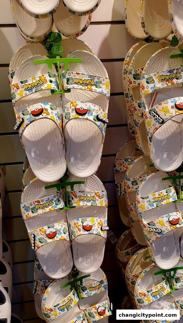 Crocs sandals featuring a colorful Pokemon-themed design with Pikachu and Pokeballs.