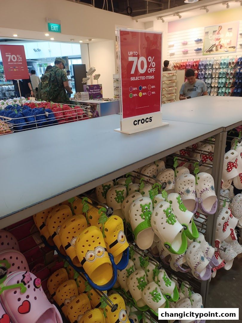 Crocs outlet store with a large display of colorful Crocs shoes and a sale sign.