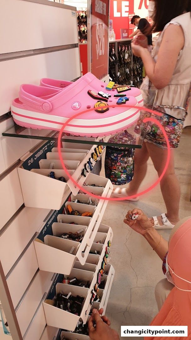 Pink Crocs with Jibbitz charms displayed next to a selection of Jibbitz.