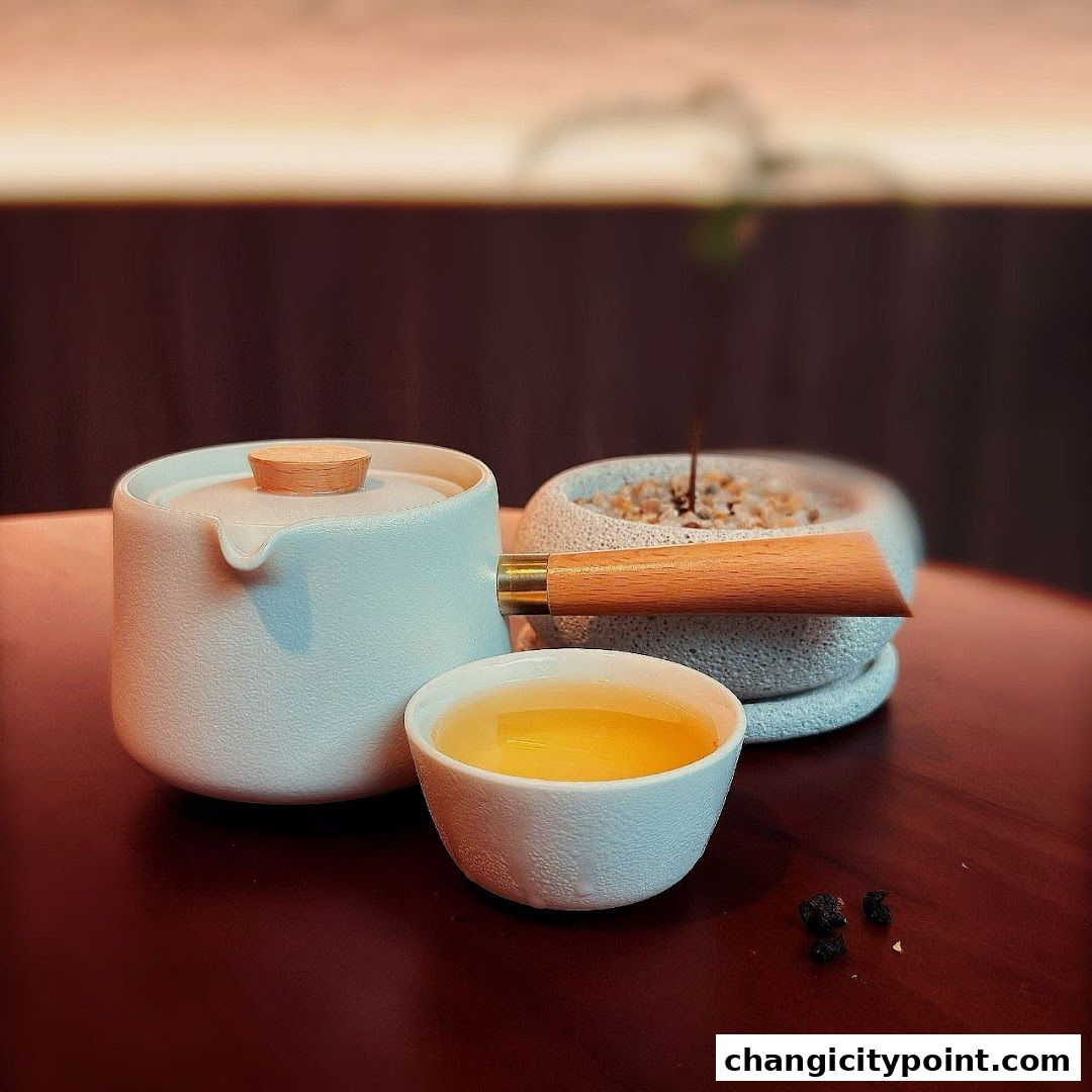 A white tea set with a cup of tea and a small decorative plant.
