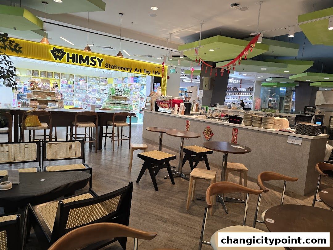 Interior view of a cafe and stationery shop with seating and merchandise displays.