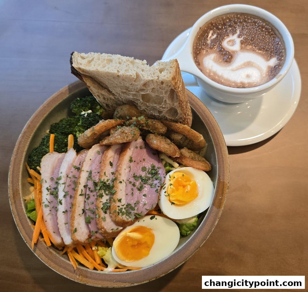 A hearty salad with sliced duck, eggs, vegetables, bread, and a latte with latte art.