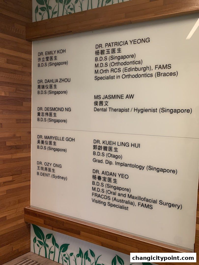 A list of dental practitioners and their qualifications displayed on a white board.