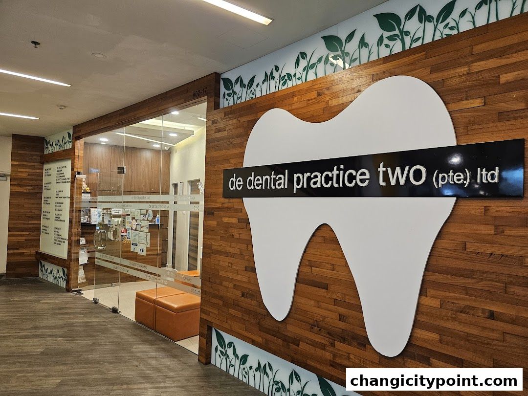 The entrance to De Dental Practice Two Ltd, featuring a large tooth logo and wooden paneling.