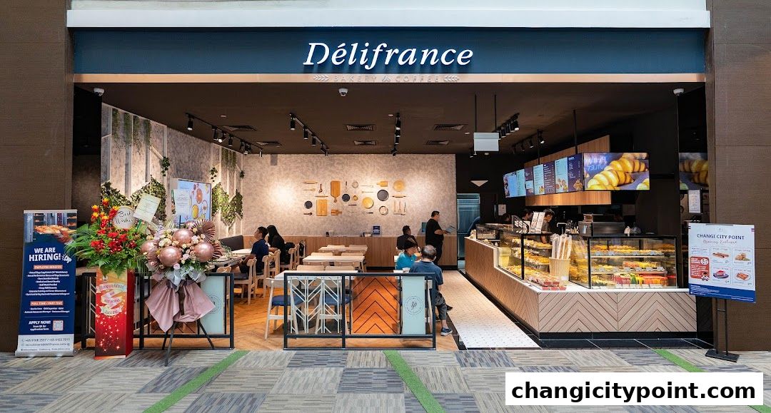 The exterior of Delifrance bakery and coffee shop with display cases and seating.
