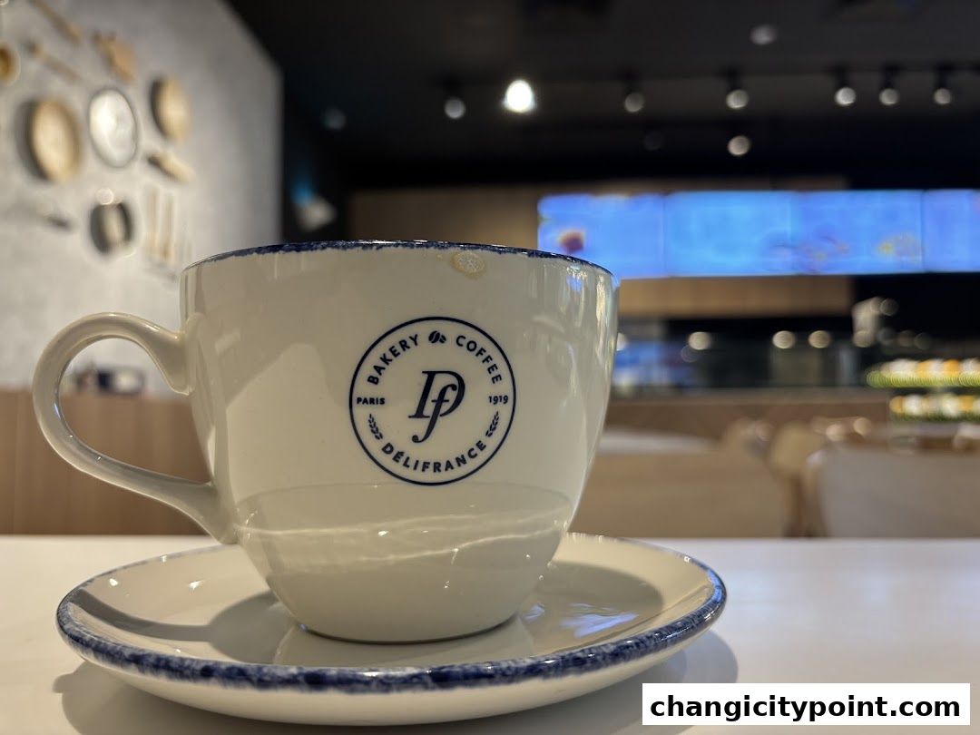 A close-up of a Delifrance coffee cup and saucer with the shop's logo.