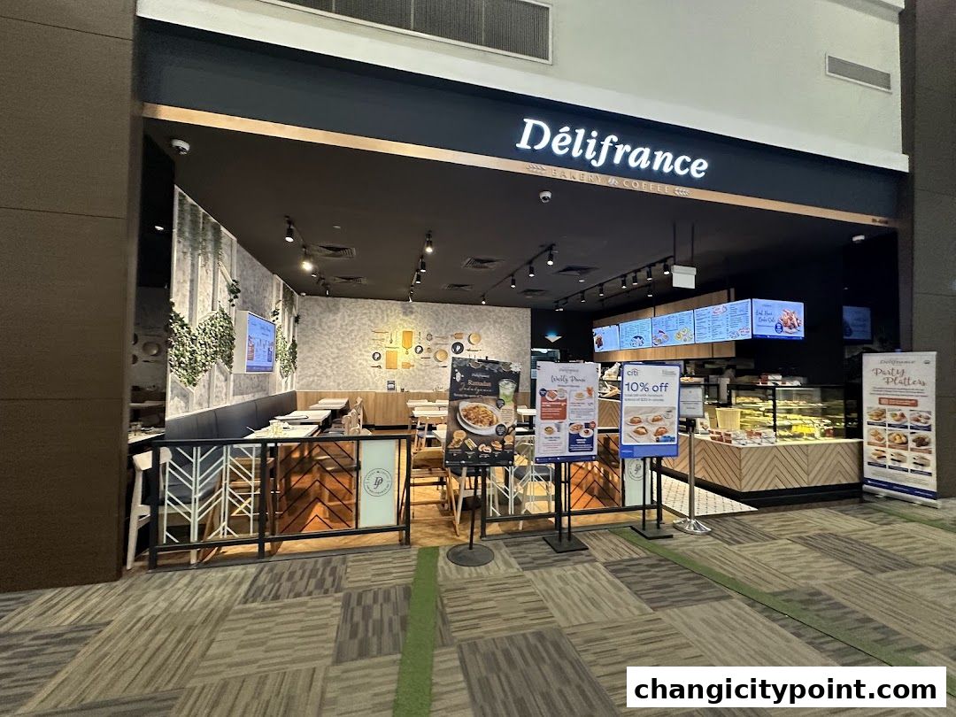 Exterior view of Delifrance bakery and coffee shop with seating and display cases.