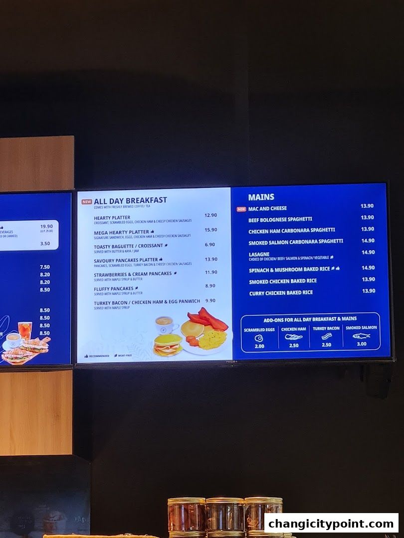 A digital menu board displaying breakfast and main course options with prices.