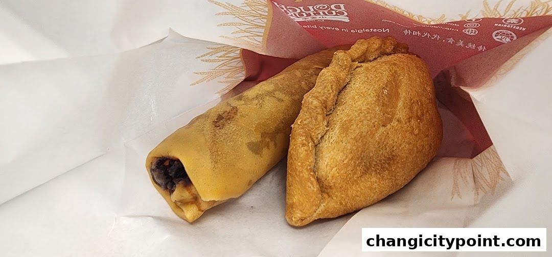 Two freshly baked pastries from Dough Culture, one rolled and one empanada-shaped.