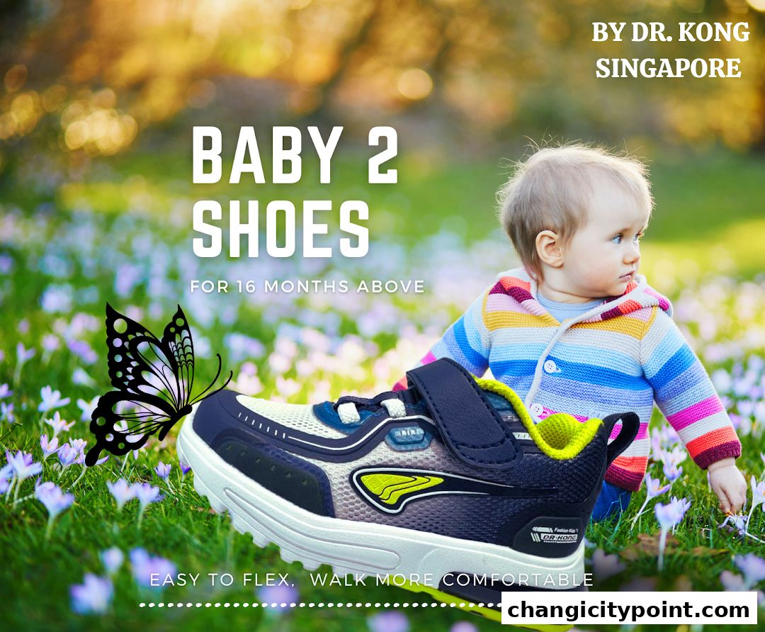 A baby wearing a colorful sweater next to a Dr. Kong baby shoe in a grassy field.