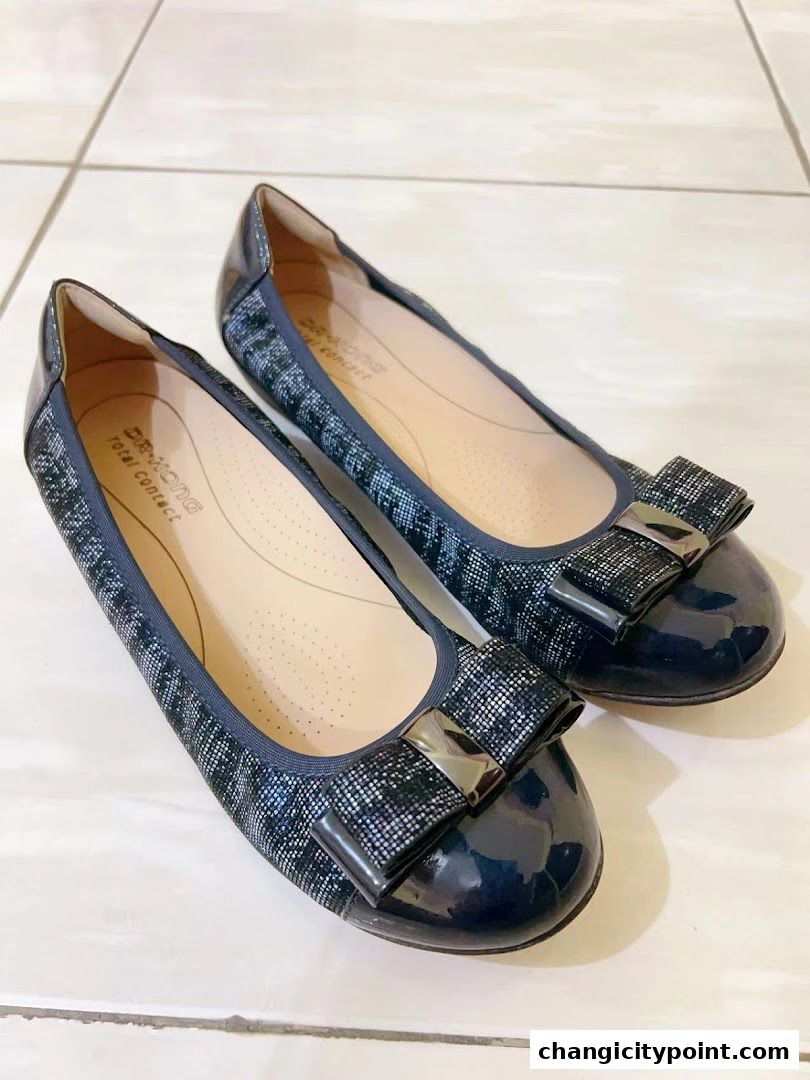 A pair of stylish navy blue ballet flats with bow accents from Dr. Kong.
