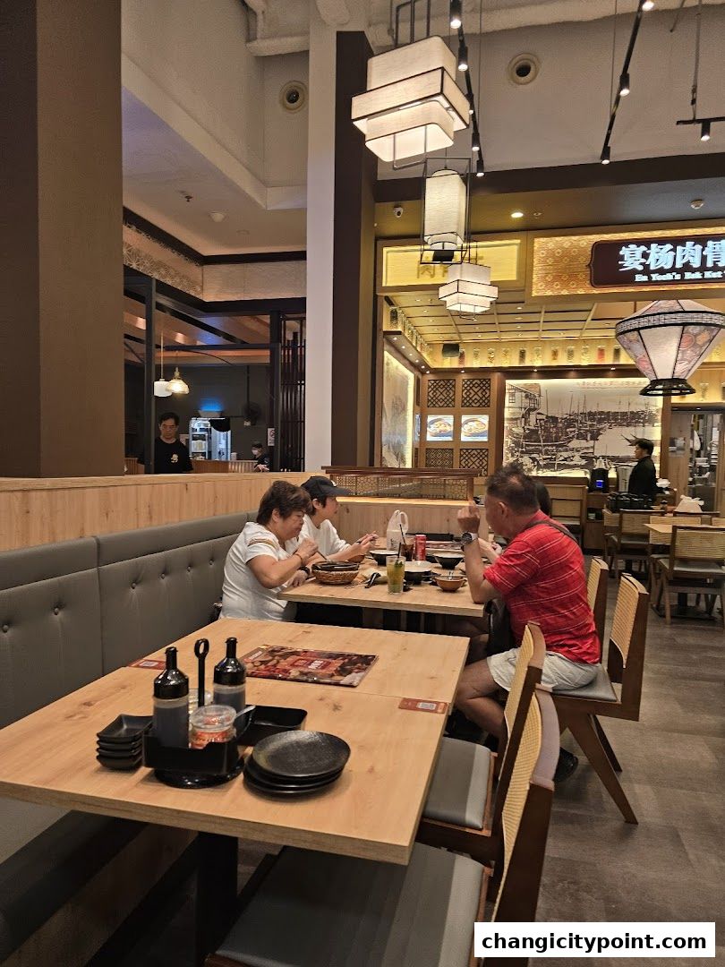 Diners enjoy a meal at En Yeohs Bak Kut Teh restaurant with traditional decor.