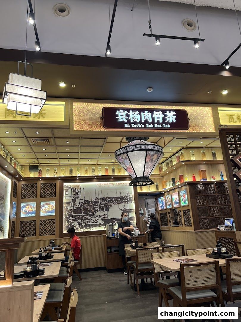 Interior of En Yeohs Bak Kut Teh restaurant with tables, chairs, and decor.