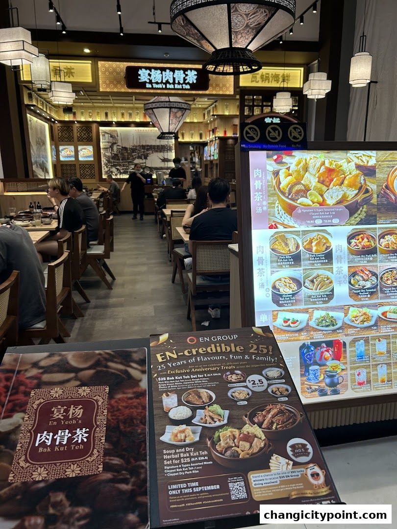 Interior of En Yeoh's Bak Kut Teh restaurant with customers and a digital menu.
