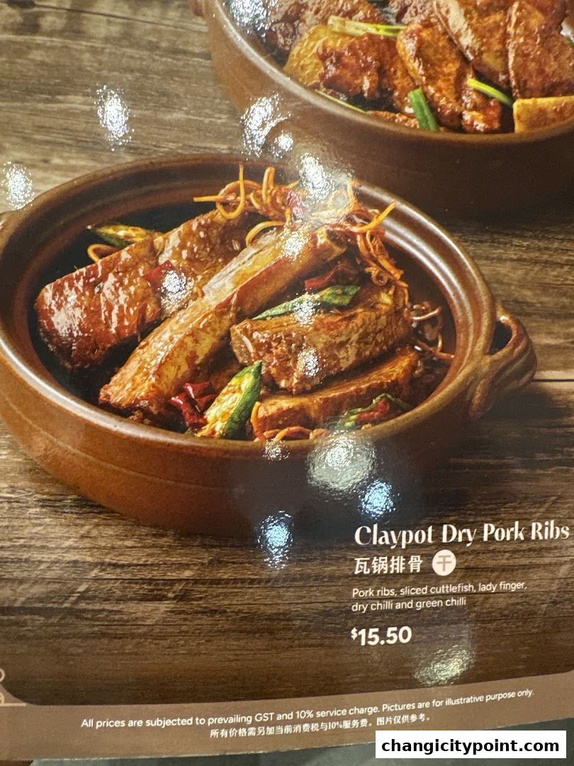 A close-up of a claypot dish with pork ribs, lady finger, and chili.