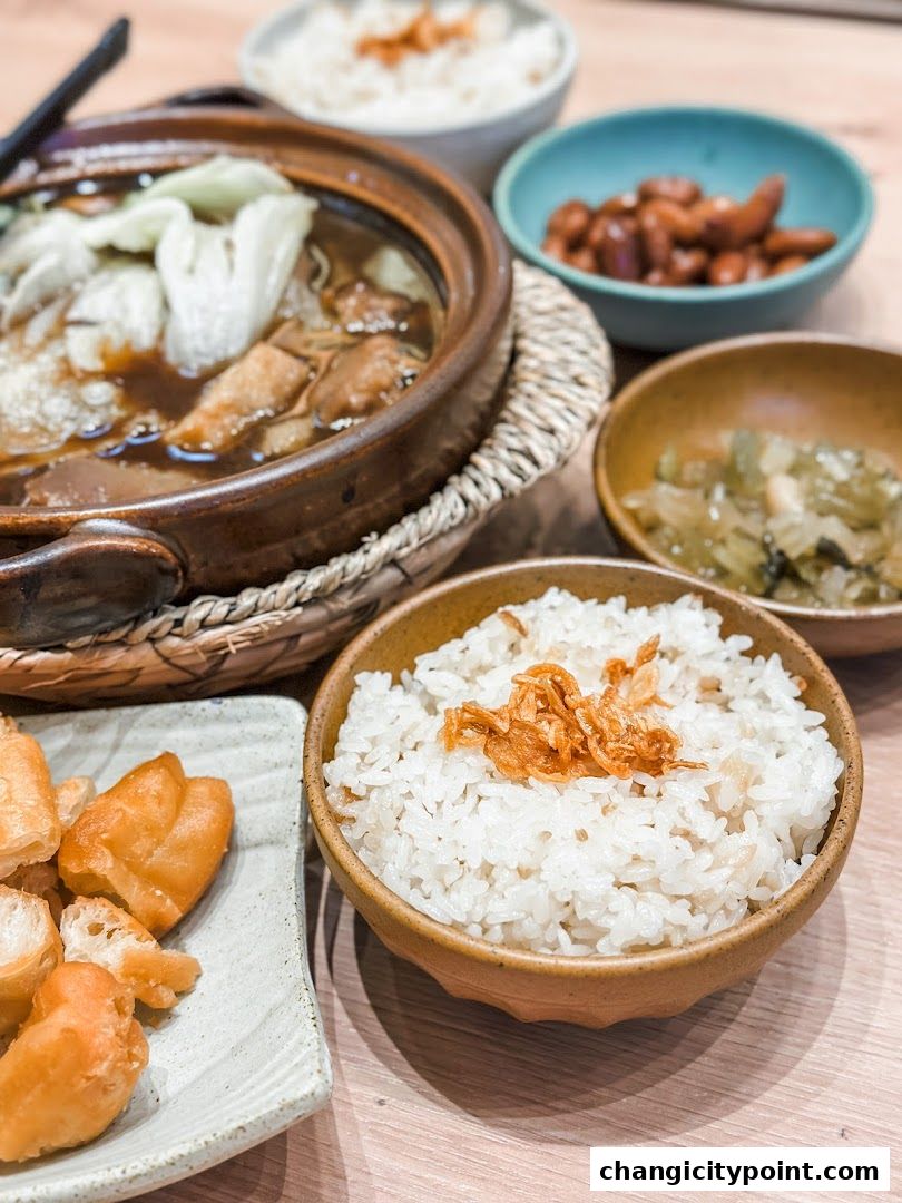 A close-up of a hearty Bak Kut Teh meal with rice and side dishes.