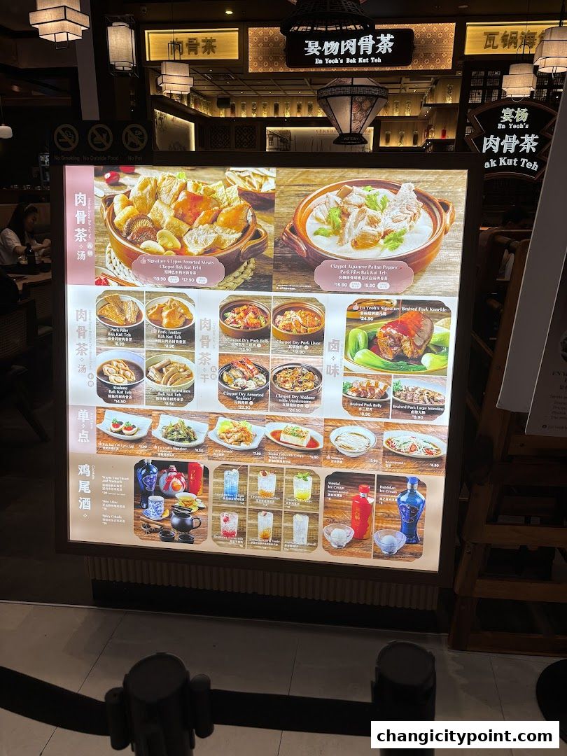 A brightly lit menu board showcasing various Bak Kut Teh dishes and side orders.