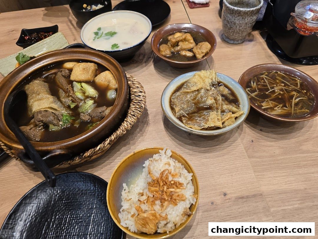 A table laden with delicious bowls of Bak Kut Teh, rice, and side dishes.