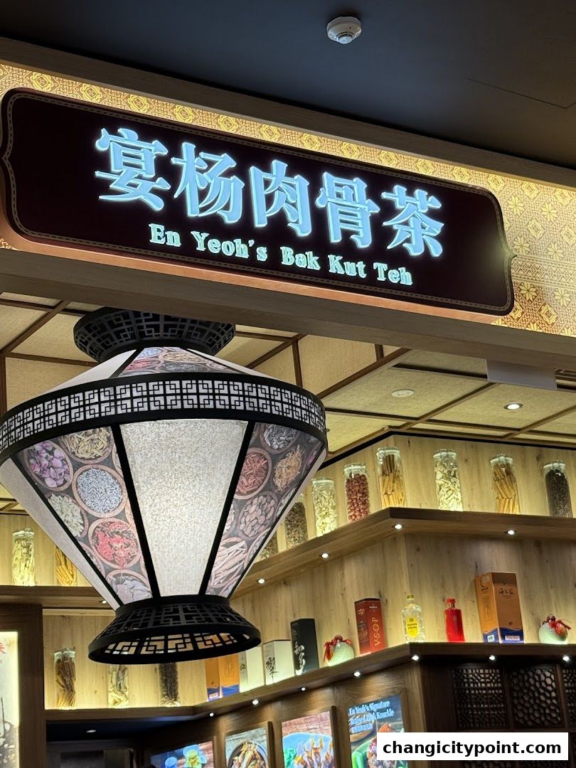 The illuminated sign for En Yeoh's Bak Kut Teh above a decorative lamp.