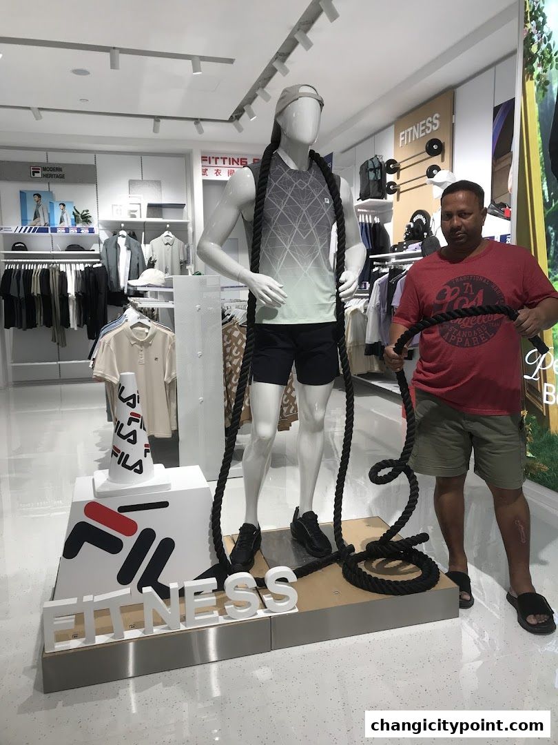 Mannequin dressed in Fila sportswear with a man holding a rope in a Fila store.