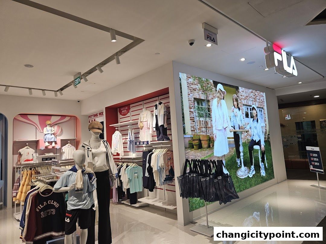Interior view of a FILA outlet store showcasing apparel on mannequins and racks.