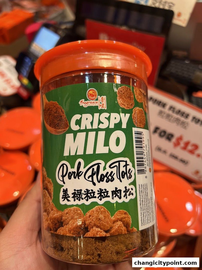 A hand holds a clear plastic container of Crispy Milo Pork Floss Tots.