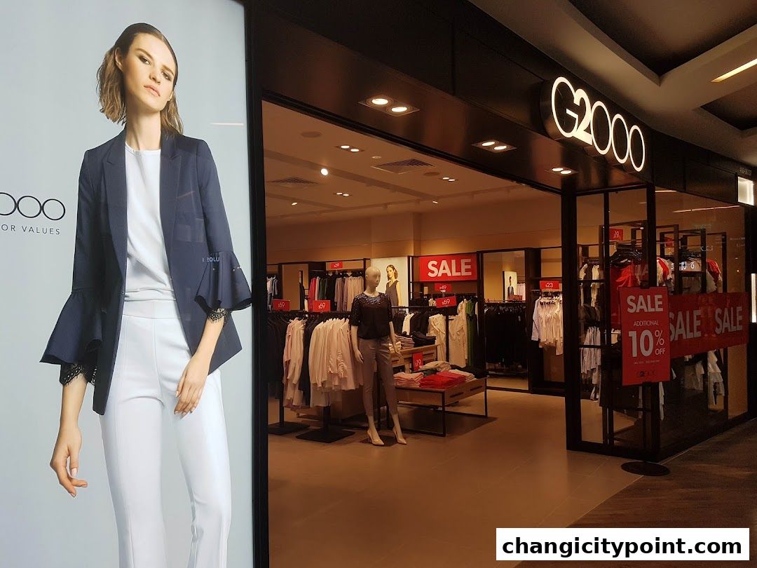 G2000 fashion store entrance with sale signs and mannequins displaying clothing.