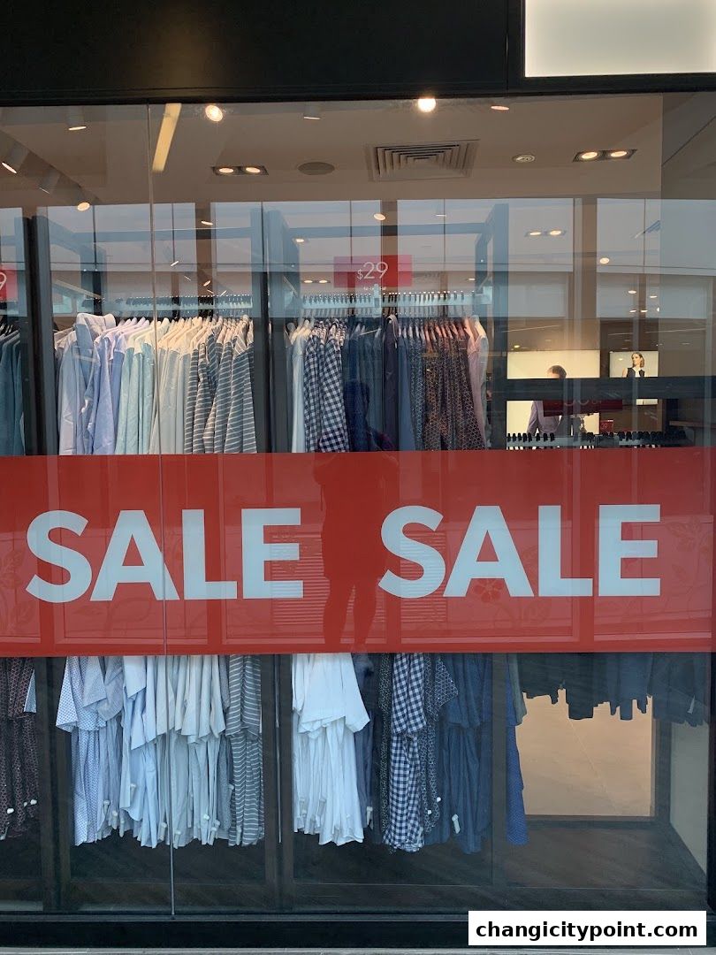 G2000 shop window displaying a 'SALE' banner and various clothing items on hangers.