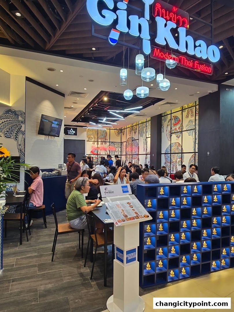 Interior of a busy Thai fusion restaurant with patrons dining and a prominent menu stand.