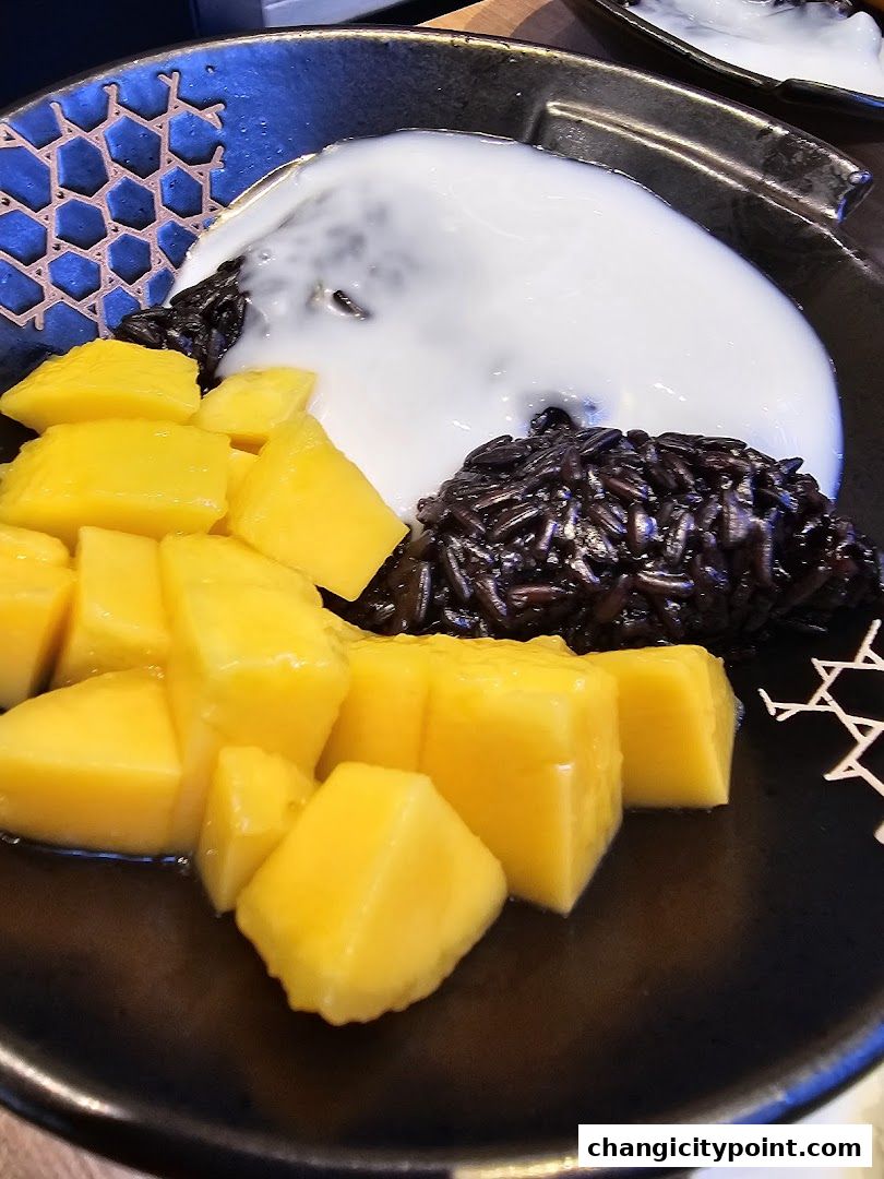 A close-up of mango sticky rice with black rice and coconut milk.