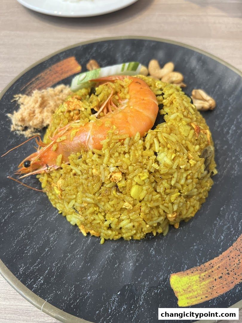 A close-up of a delicious shrimp fried rice dish served on a dark plate.