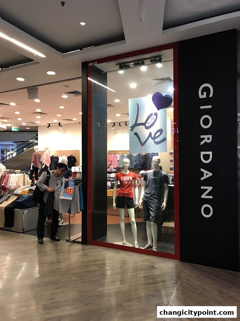 Giordano shop front with mannequins displaying casual wear and a man browsing clothes.