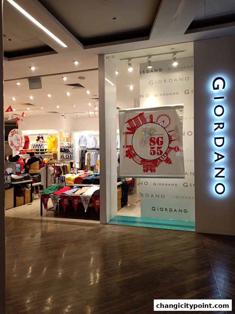 The entrance of a Giordano clothing store with merchandise displayed inside and a promotional banner.