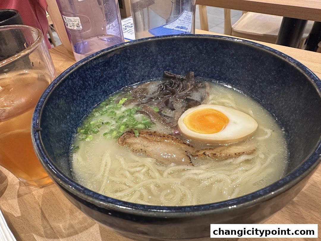 A close-up of a delicious bowl of ramen with noodles, egg, and meat.
