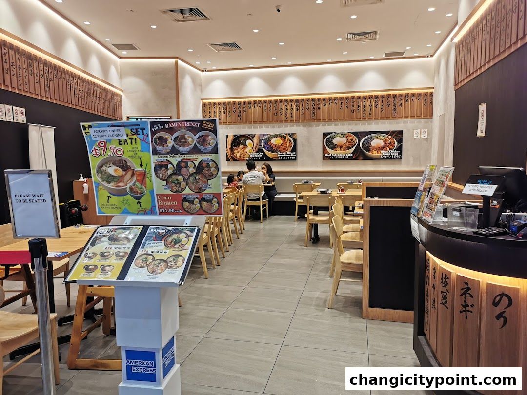 Interior of a ramen restaurant with seating, menus, and a counter.
