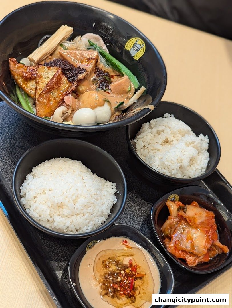 A bowl of Mala Tang with rice, kimchi, and dipping sauce.